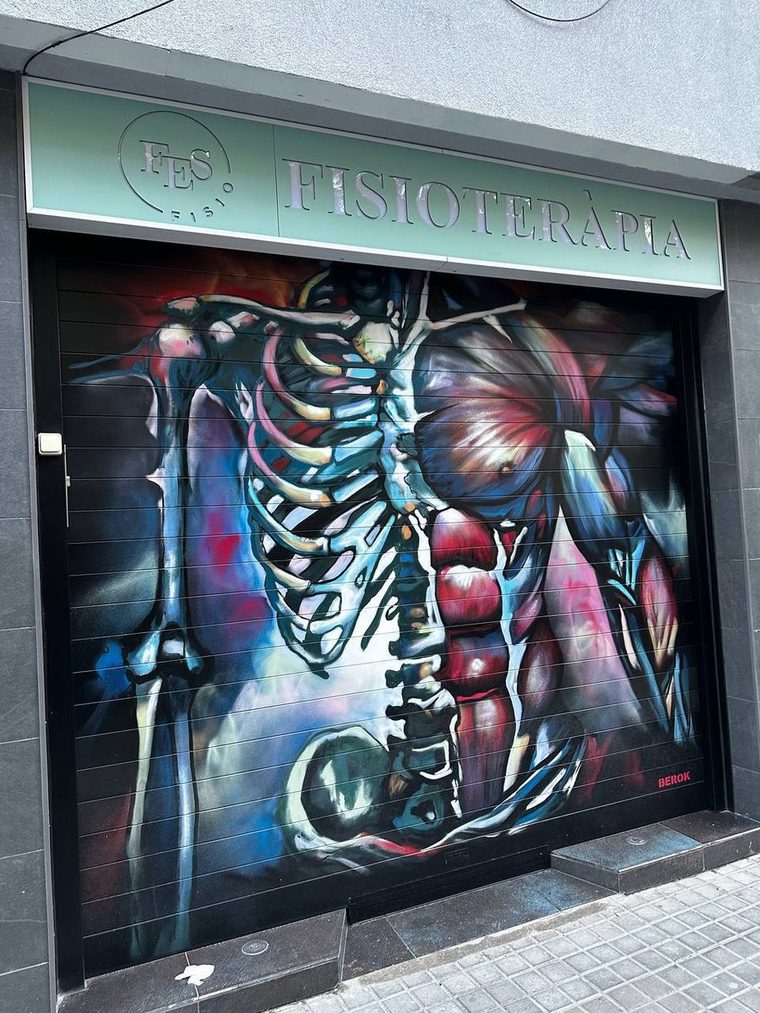 Fachada de FES Fisioterapia en la Ronda del Guinardó, Barcelona, con el mural anatómico pintado en la persiana